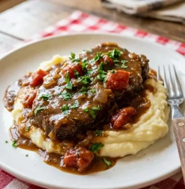 Classic Swiss Steak served with savory tomato gravy on a plate