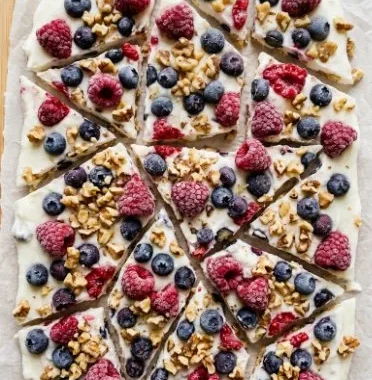 Frozen Yogurt Bark 1 Frozen yogurt bark topped with berries and nuts on a marble surface
