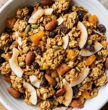 Homemade granola made with leftover bread, nuts, and dried fruits in a bowl.