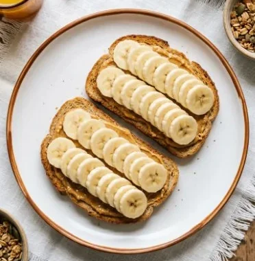 Delicious slice of banana toast topped with peanut butter and banana slices.