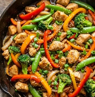 Colorful easy chicken stir-fry served in a bowl with veggies and rice