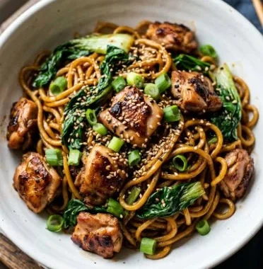 Sesame Noodles with Chicken 2 A bowl of Sesame Noodles with Chicken garnished with vegetables and sesame seeds.